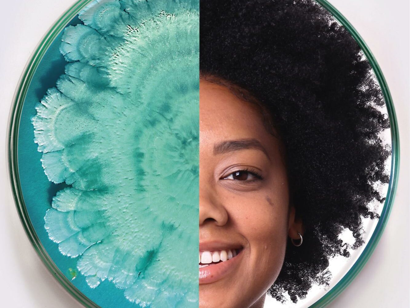 2021_Microbes + Faces 12 A circular image split in half; the left side features a teal microbial growth pattern, while the right side shows the smiling face of a person with afro-textured hair. The contrasting halves are visually striking.