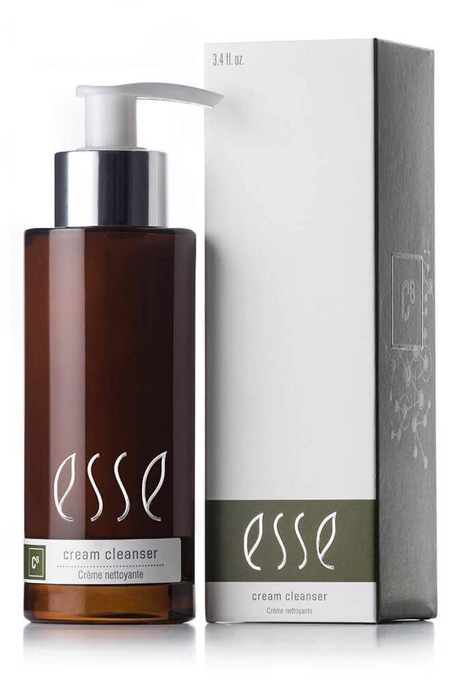A brown pump bottle labeled "Esse Cream Cleanser" is placed next to its matching white and green box. Both the bottle and the box feature the same "Esse" branding, clearly indicating that the product inside is a cream cleanser.