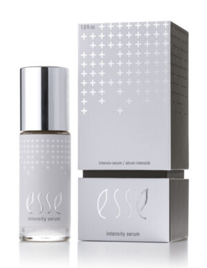 A bottle of Esse Intensity Serum with a silver cap stands next to its matching silver and white box, both displaying minimalist cross patterns and modern typography.