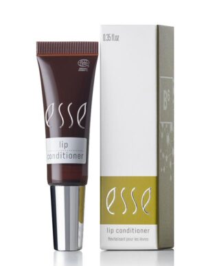 An Esse Lip Conditioner tube sits beside its open, partially-visible packaging. The dark brown tube features a silver cap and white text that reads "Esse Lip Conditioner". Its box displays yellow and white sections with the same text and a B6 symbol.