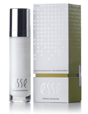 A sleek white and green box with silver accents is positioned beside a cylindrical bottle featuring a shiny metallic cap. The product, labeled "Esse Defence Moisturiser," showcases a minimalist design highlighted by a white background and subtle cross patterns.