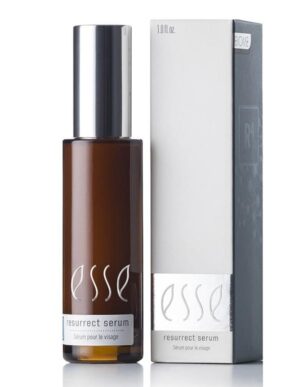 A brown bottle of Esse Resurrect Serum stands beside its white and gray packaging box. The bottle is equipped with a silver pump cap, and the label displays "Esse Resurrect Serum" along with "Serum pour le Visage." The same text also appears on the packaging.