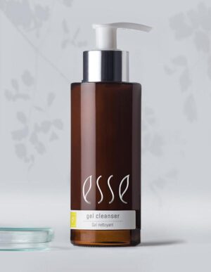 A brown bottle of Esse gel cleanser with a white pump dispenser. The label reads "gel cleanser" in white text and "Gel nettoyant" below it. The bottle is placed against a gray background with subtle leaf patterns.
