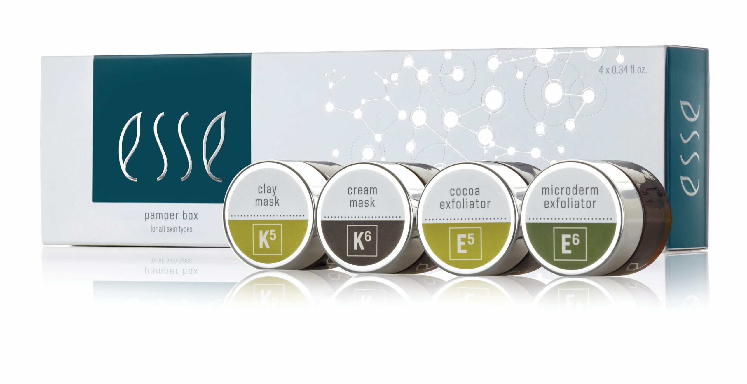 The Esse Limited Edition Festive Pamper Box is displayed along with its four skincare products: Clay Mask, Cream Mask, Cocoa Exfoliator, and Microderm Exfoliator. Each product comes in small round containers with distinct labels in various colors.