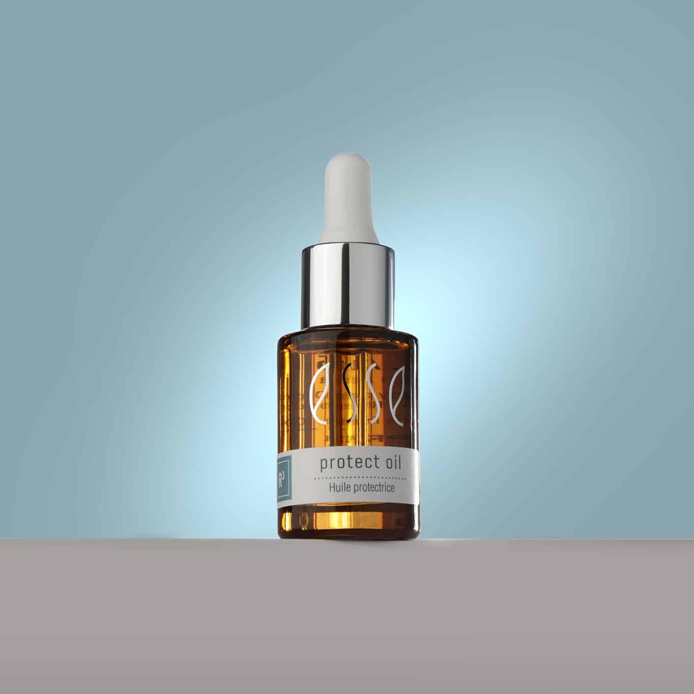 A small amber glass bottle of Esse Protect Oil stands on a neutral surface against a gradient pale blue background. The bottle, with a silver and white dropper cap, features the brand name "Esse" and a label indicating it is protective oil.
