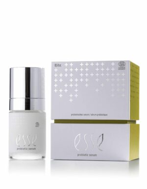 A bottle of Esse Probiotic Serum with a silver cap stands beside its white and yellow box, which features plus sign patterns and the product name.